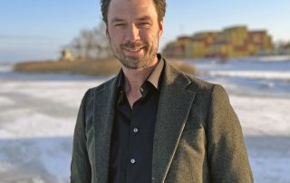 David Hellstedt, affärsutvecklare, i vintrigt landskap med containerfartyg och containerstack i fonden.