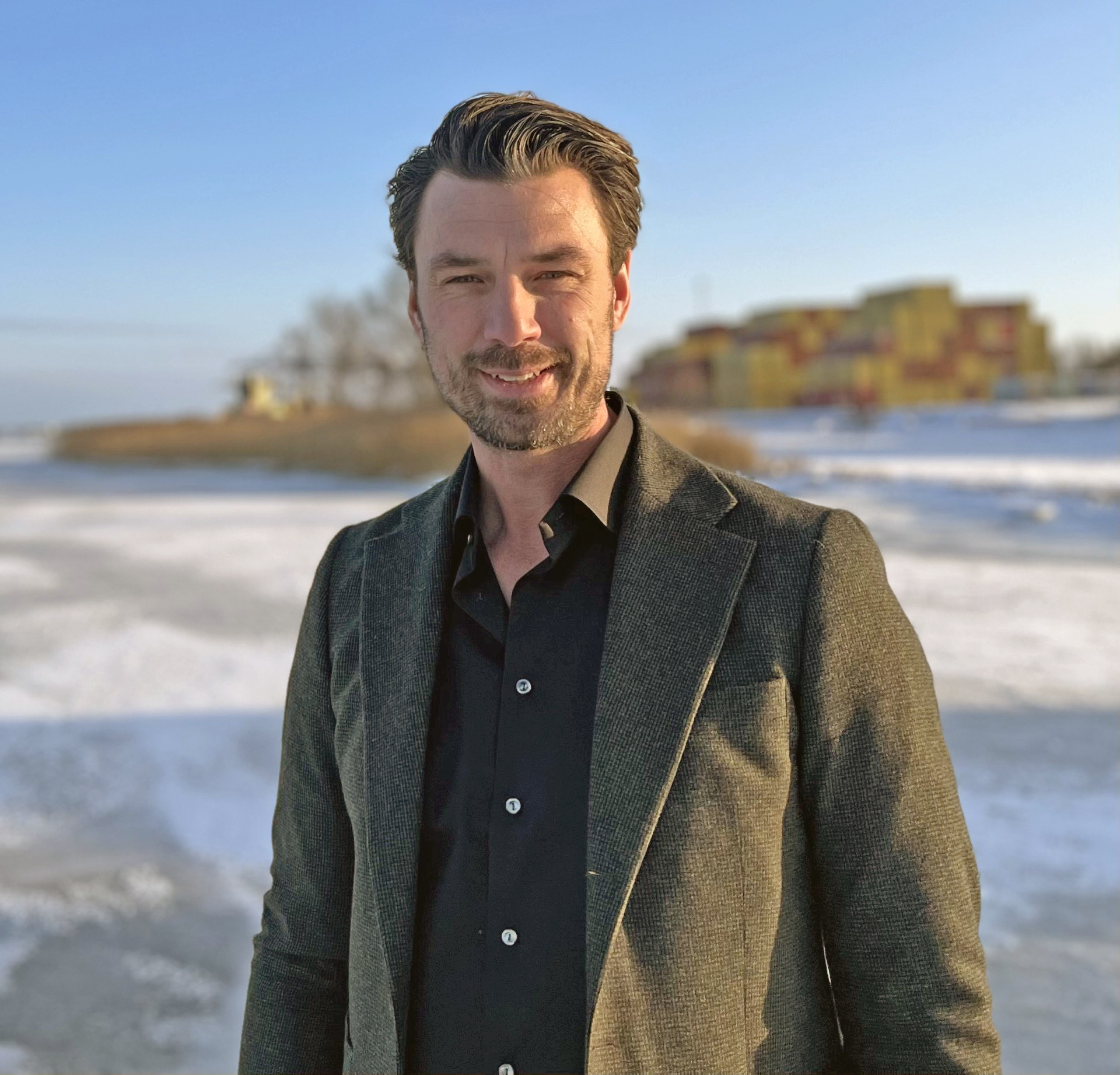 David Hellstedt, affärsutvecklare, i vintrigt landskap med containerfartyg och containerstack i fonden.