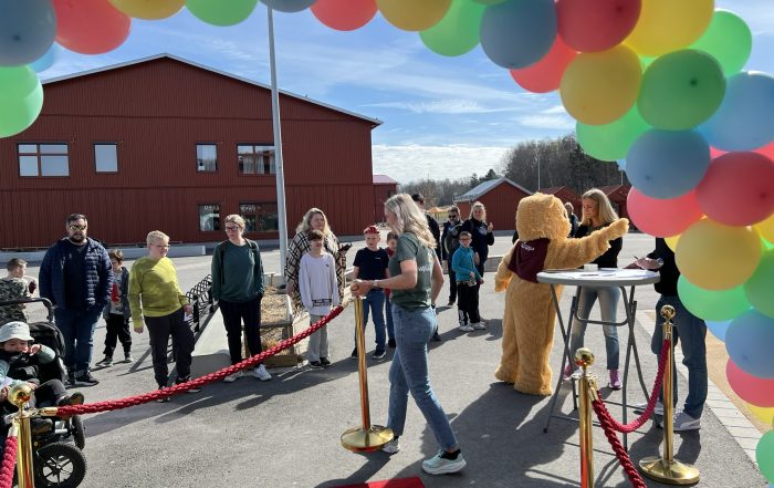 Ballongportal, väntande barn och en person utklädd till björn.