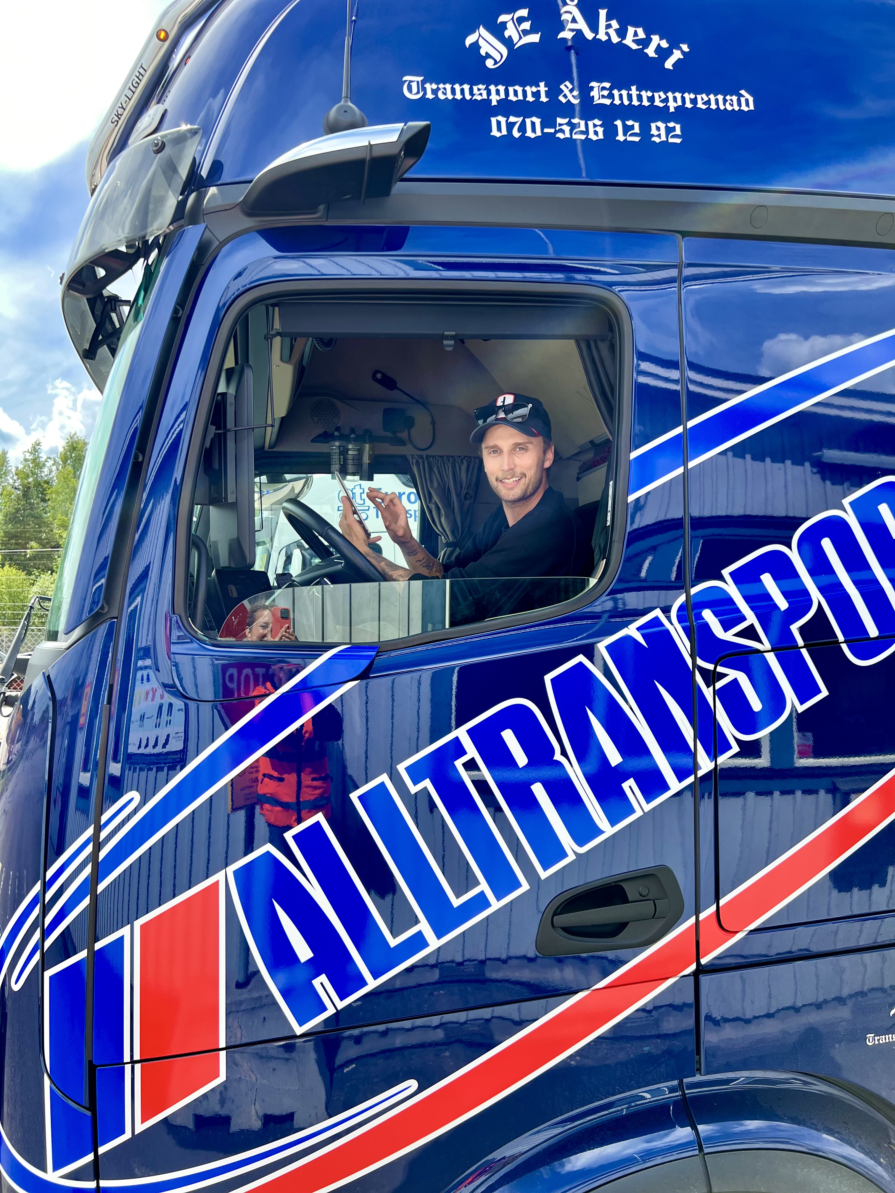 Chaufför i bil En glad chaufför tittar ut ur sin lastbil.