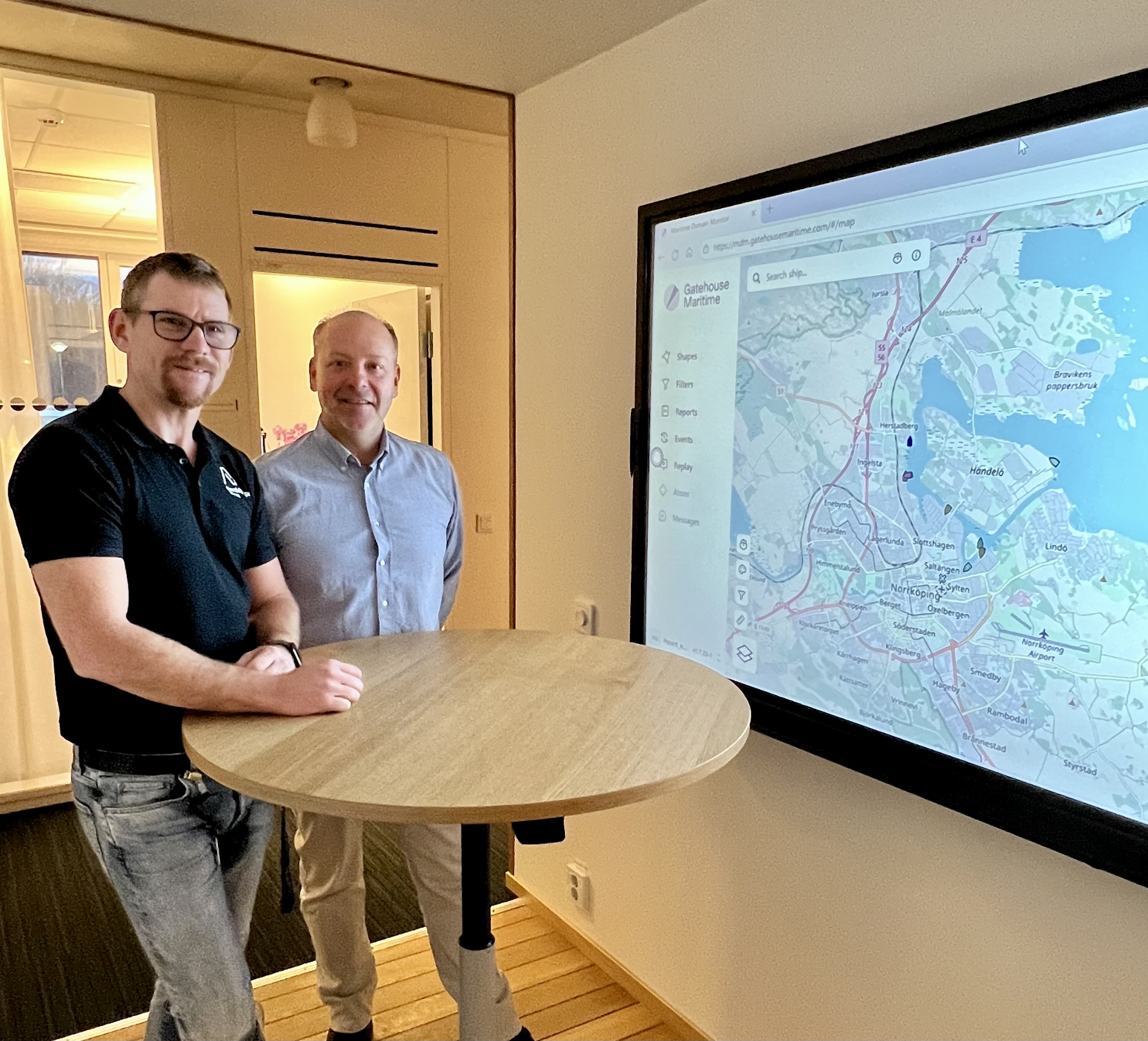 Rickard Stensson, Digitaliseringsansvarig och Joakim Pettersson, Hamnkapten framför bildskärm som visar karta över hamnområdet.