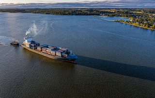 Containerfartyg och bogserbåt på väg in mot Norrköpings Hamn.
